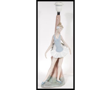 A Lladro ceramic figural table lamp in the form of a ballerina complete with lamp shade. Measures 49cm high.