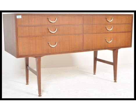 A vintage retro 20th Century teak wood sideboard of Danish influence having six drawers with brass handles, Raised on tapered