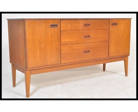 A vintage retro 20th century teak sideboard having a bank of three central drawers flanked by cupboards either side, raised o
