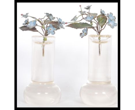 A pair of early 20th Century French hand worked enamel on metal floral flower sprays in glass column stands in the manner of 