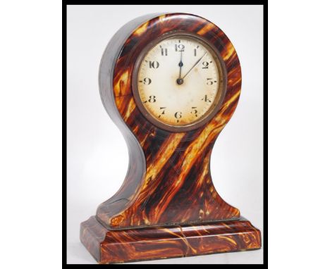A late 19th / early 20th Century tortoiseshell balloon clock having a white enamel face with bold numeral chapter ring and fa