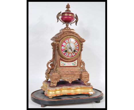 A 19th Century style French Continental clock. The ormolu clock having red ceramic ground features with painted panels of cla