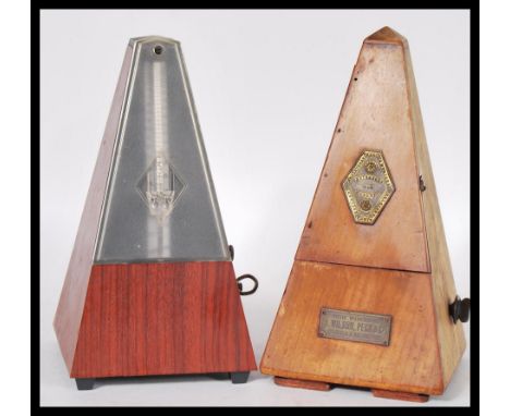 A vintage 20th Century Triangular cased wooden metronome with applied brass mounts Metronome by Maelzel together with another