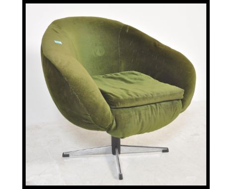 A vintage retro 20th Century circa 1960's swivel egg chair upholstered in green velour material and raised on a chrome four p