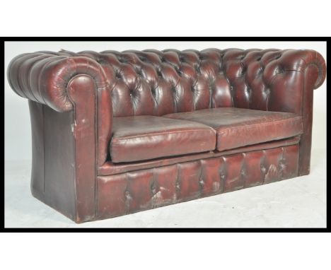 A retro vintage ox blood red leather chesterfield sofa with barrel rolled arms and backrest being button backed. The front of