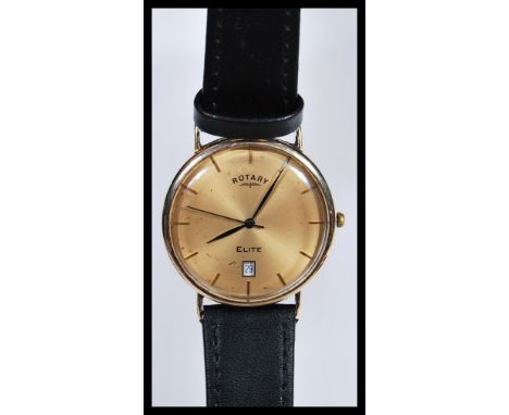 A 9k 9ct gold Rotary Elite gents watch having a champagne dial with glt baton numerals and faceted hands. Date aperture to si
