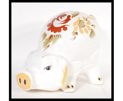 A vintage 20th Century 1960's large ceramic money bank box in the form of a pig having hand painted Delft style floral sprays