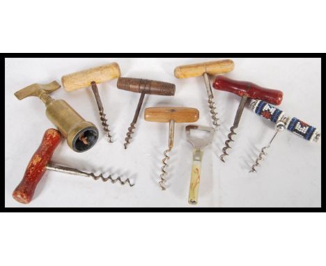 A collection of eight antique and vintage corkscrews to include an Art Deco nude bottle opener, wooden examples, bead handled