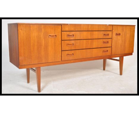 A vintage retro 20th Century teak wood sideboard chest of drawers having a central bank of four drawers flanked by cupboards 