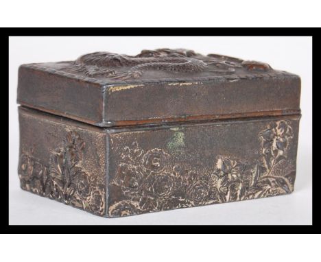 A 19th Century Chinese white metal snuff box / pill pot having relief decoration depicting a dragon chasing the flaming pearl