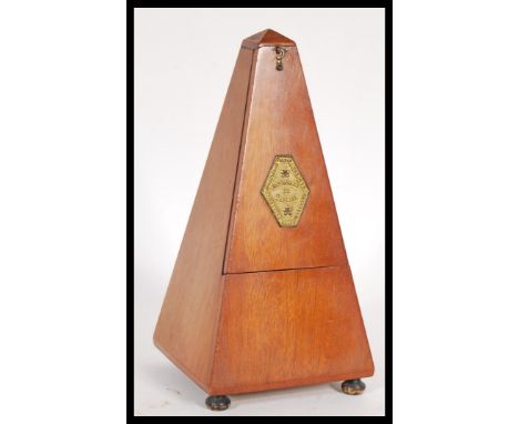 A 20th Century vintage French metronome marked 'Metronome De Maelzel', of typical wooden form, raised on bun feet. Measures 2