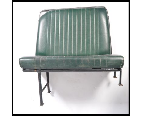 Two vintage mid century Industrial original bus / coach seats being raised on the tubular black frames with green padded viny