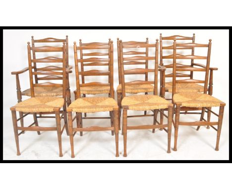 A set of 8 early 20th century beech wood country ladderback dining chairs being raised on turned legs with rattan weave seats