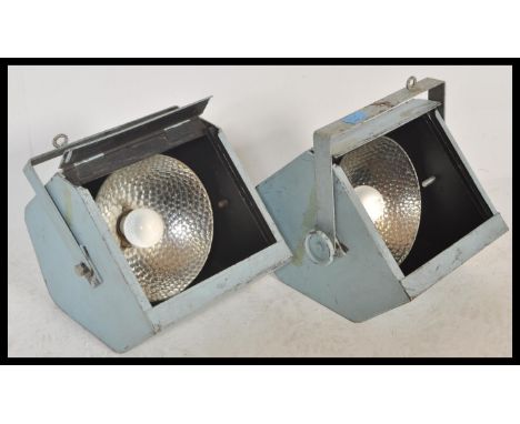A pair of vintage retro 20th Century theatre stage spotlight spot lamps having brushed steel metal cages with adjustable moun