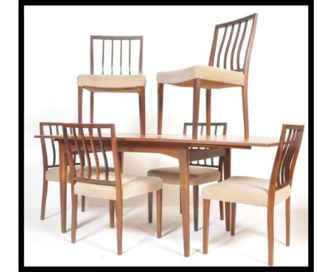 A vintage retro 20th Century teak Danish influence dining table suite with a set of six vintage teak wood chairs. The extendi