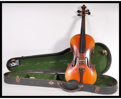 A vintage 20th Century violin musical instrument having a two piece maple back with spruce front. Ebonised neck and tuning pe