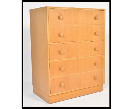 A vintage retro 20th Century Danish influence chest of drawers having a bank of five drawers with turned knob handles raised 