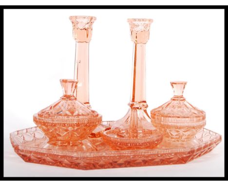 An early 20th Century Art Deco 1930's peach glass dressing table vanity set consisting of octagonal tray with pair of candles