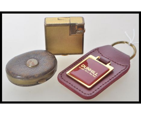 A vintage 20th Century smoking interest Dunhill Monaco cigarette lighter having a gold tone finish along with a red leather D