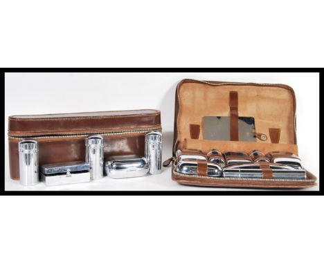 Two vintage 20th Century Gentleman's travelling cased vanity sets having glass bottles and pots with chrome or white metal li