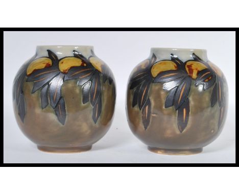 A pair of early 20th Century Royal Doulton ceramic vases of globular form having hand painted decoration of Lemons. Impressed