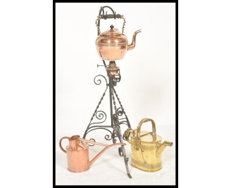 A vintage 20th Century Arts and Crafts copper spirit kettle raised on a wrought Iron stand together with two vintage watering