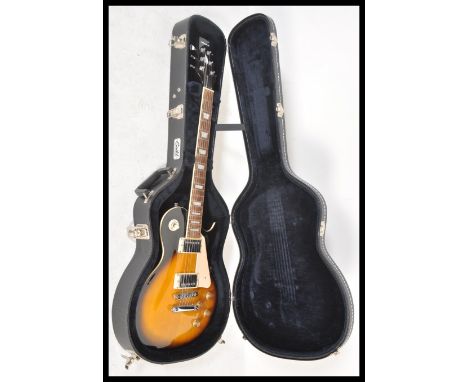 A vintage Aria made Gibson style six string electric guitar having a two tone tobacco sunburst body, faux mother of pearl inl
