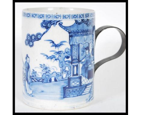 An 18th Century ceramic blue and white glazed brush pot having a later applied iron scroll handle, the pot decorated with cou