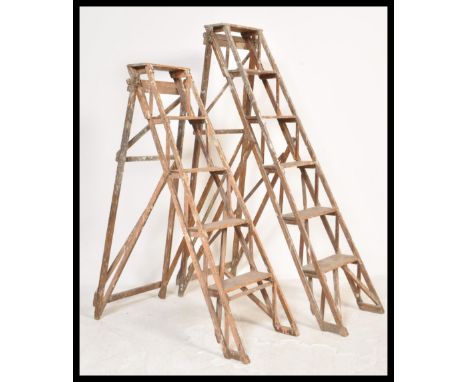 Two good early 20th century Industrial wooden trestle ladder. Each with A-frame design having lattice worked sides and angled