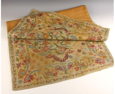 A crewel work style panel, 19th century, extensively worked with floral motifs within a floral and scroll border, hessian bac