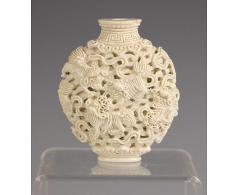 A Chinese porcelain carved and reticulated snuff bottle, Qianlong/Jiaqing, of compressed oval form decorated with playful Kyl