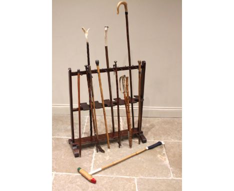 A collection of horn handled shepherds crooks and walking sticks, white metal topped canes, golf putter and a polo mallet, al