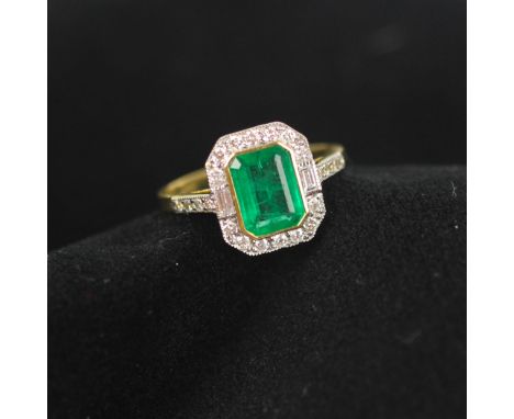 An early 20th century emerald and diamond cluster ring, circa 1940's, the central emerald cut emerald within surround of roun