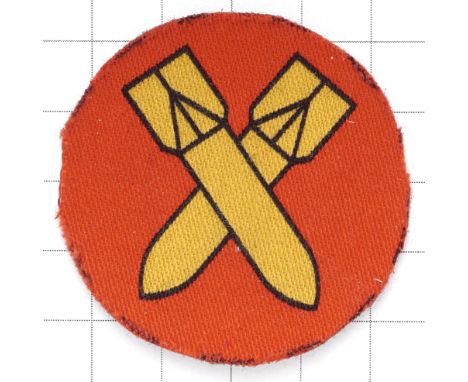 WW2 Home Guard Bomb Disposal printed cloth badge circa 1943-44.Crossed bombs in yellow on printed on red canvas disc.See “In 