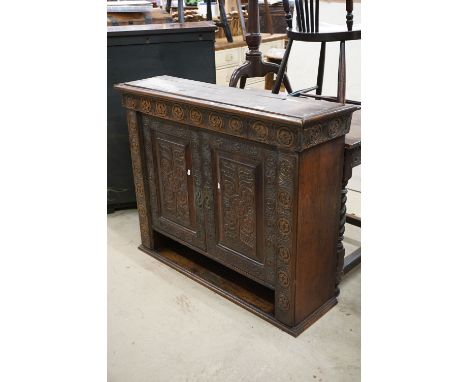 Victorian Oak Jacobean Revival Cupboard, heavily carved, the two doors opening to a fitted interior comprising an arrangement