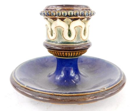 A Doulton Lambeth candlestick, in treacle coloured brown, green and blue detailing, on a raised stem with dish, 9cm high.