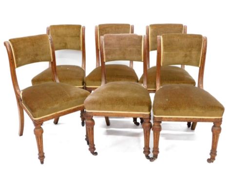 A set of six early Victorian oak dining chairs, each with a green upholstered padded back and seat on turned fluted legs with