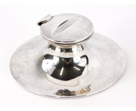 An Edward VII silver Capstan inkwell, with a hinged lid enclosing a milk glass liner, on a circular base, loaded, Birmingham 