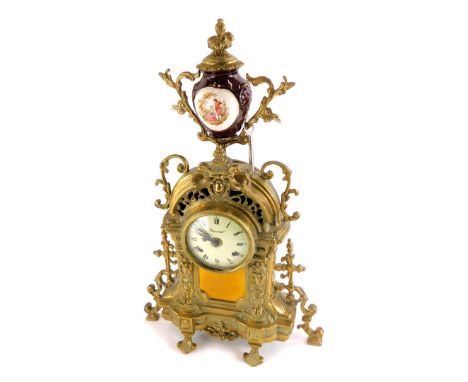 A Continental mantel clock, the rococo shaped cast brass case decorated with scrolls, the dial stamped Imperial, the urn fini