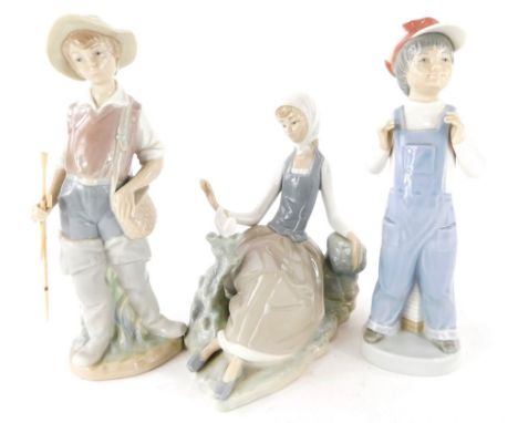 Three Lladro figures, to include lady reclined with a dove, fisherman and child with accordion, 22cm high, 22cm and 16cm high
