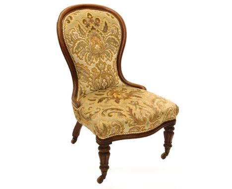 A Victorian mahogany spoon back side chair, with a padded back and seat on turned and fluted legs with ceramic castors.