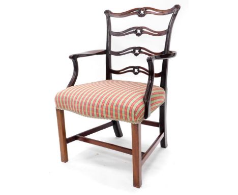 A mahogany open armchair in George III style, with a pierced carved ladder back, shaped arms and a padded seat, upholstered i