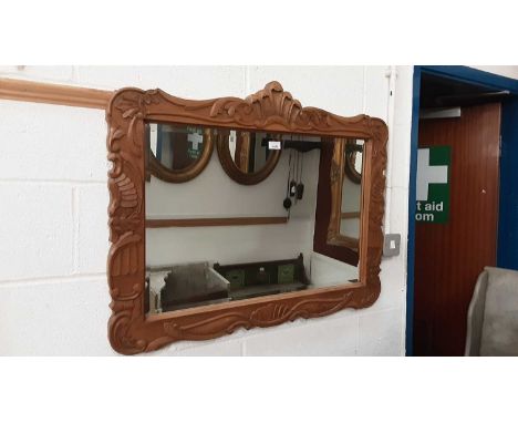 Bevelled wall mirror in carved wooden frame