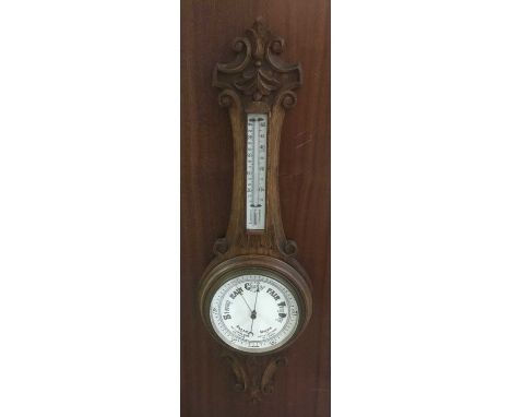 Late Victorian aneroid barometer and thermometer in carved oak case