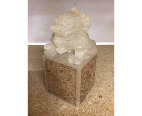 Chinese carved hard stone Foo dog on square base with engraved scroll decoration, 15cm high