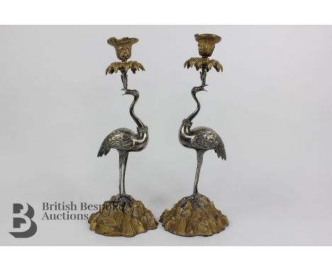 Pair of Continental mixed-metal candlesticks cast as storks, each with a foliate cast candle socket and drip pan held in the 