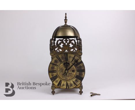 English brass lantern clock, of squared shape with domed top, strapwork turned brass finial over a circular brass face with i