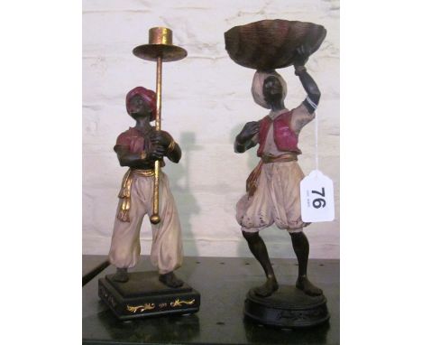 A pair of modern figures holding shell and candlestick