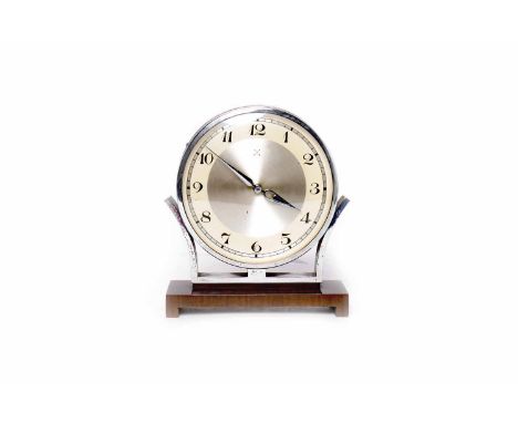 SMALL CIRCULAR MANTEL CLOCK OF ART DECO DESIGNthe dial with Arabic numerals contained in a chromium plated case, on walnut pl