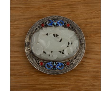 Jade and enamel buckleChinesethe oval pale green plaque carved with a carp and lotus, set in a silver metal circular mount wi